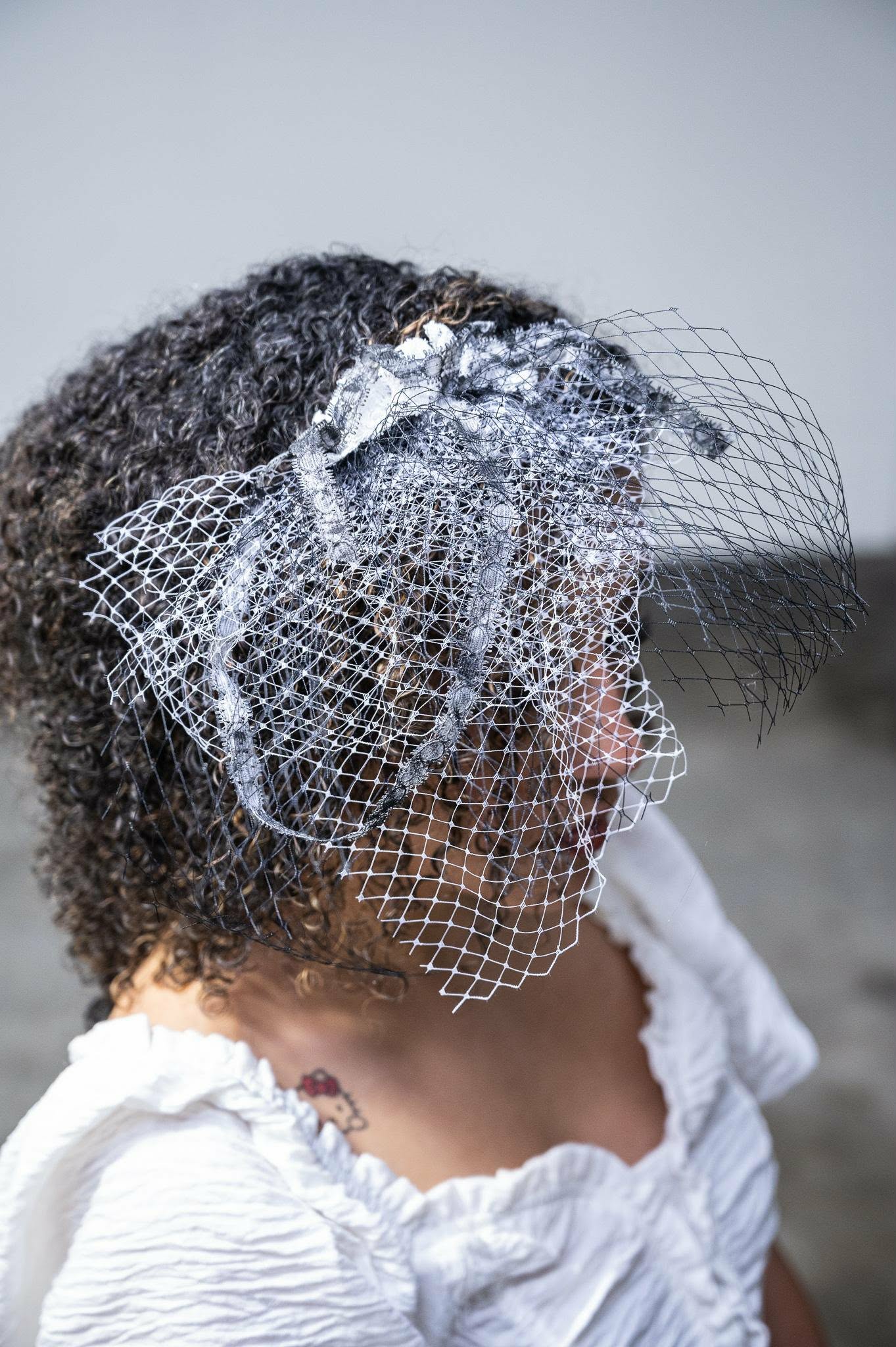 Profile showing a handmade black-and-white birdcage veil