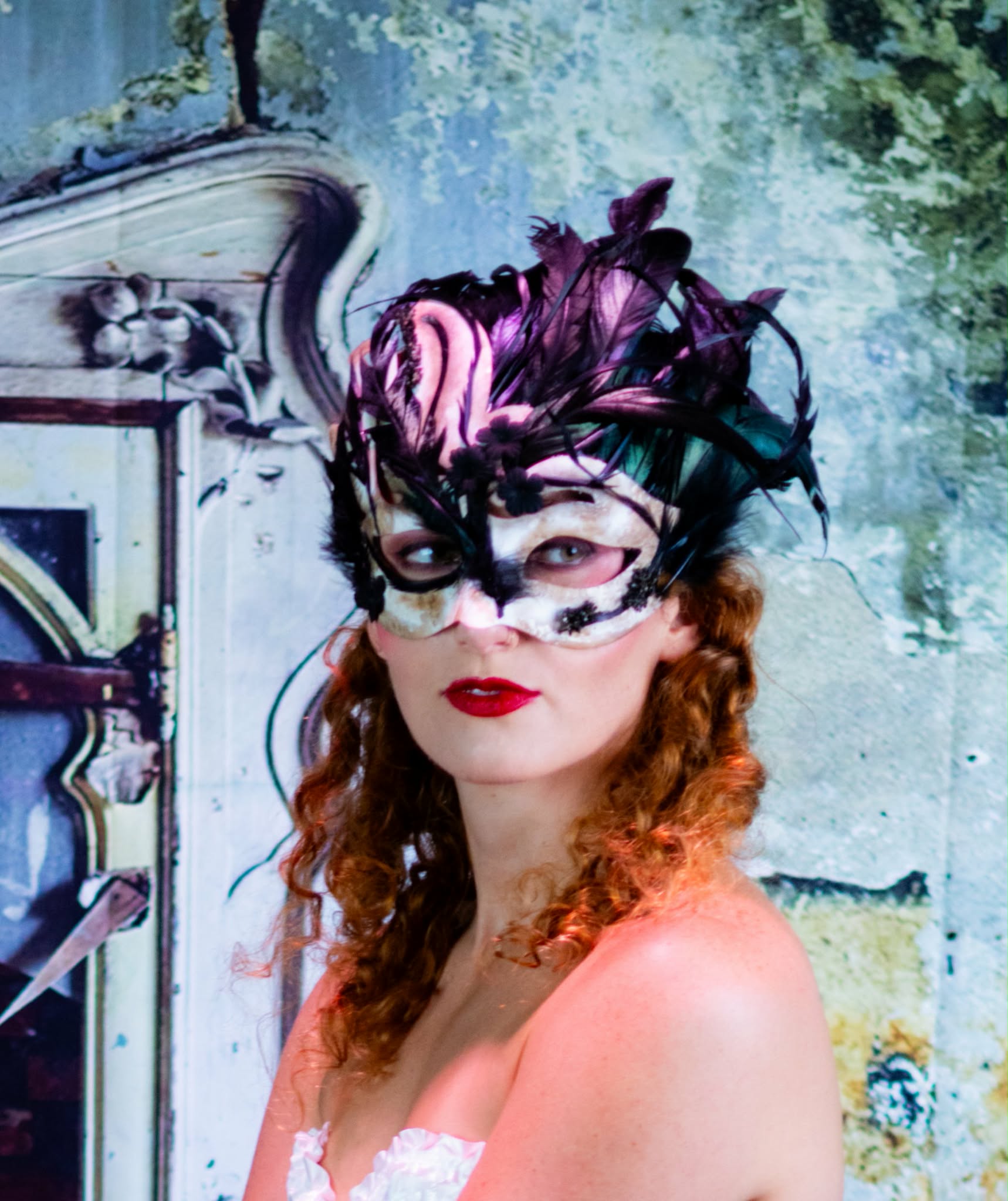 Close portrait wearing a sculptural black-and-white feather carnival mask