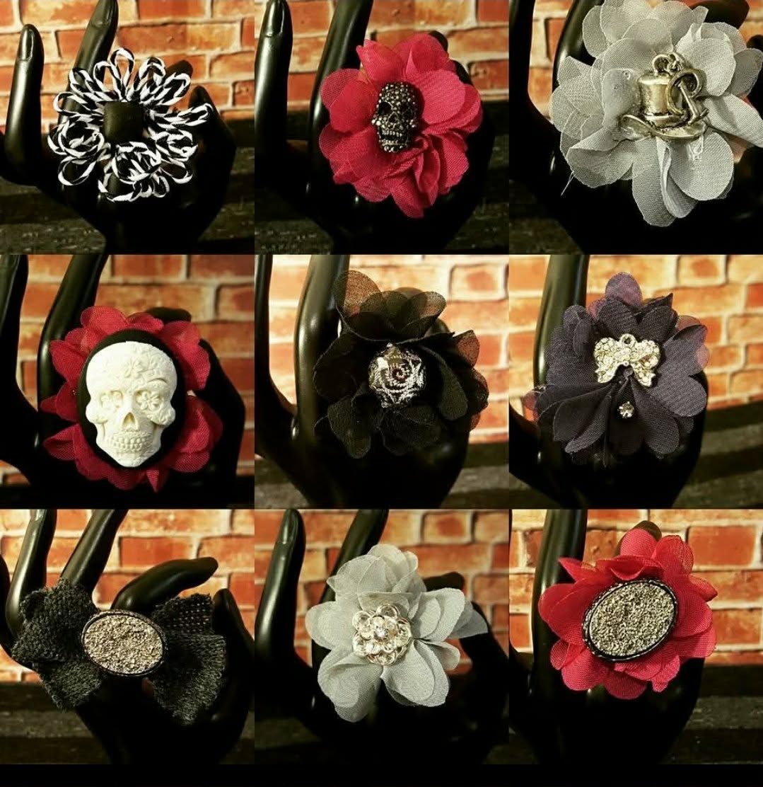 Collection of handmade black handbags decorated with fabric flowers, skulls, buttons, and sparkling centers