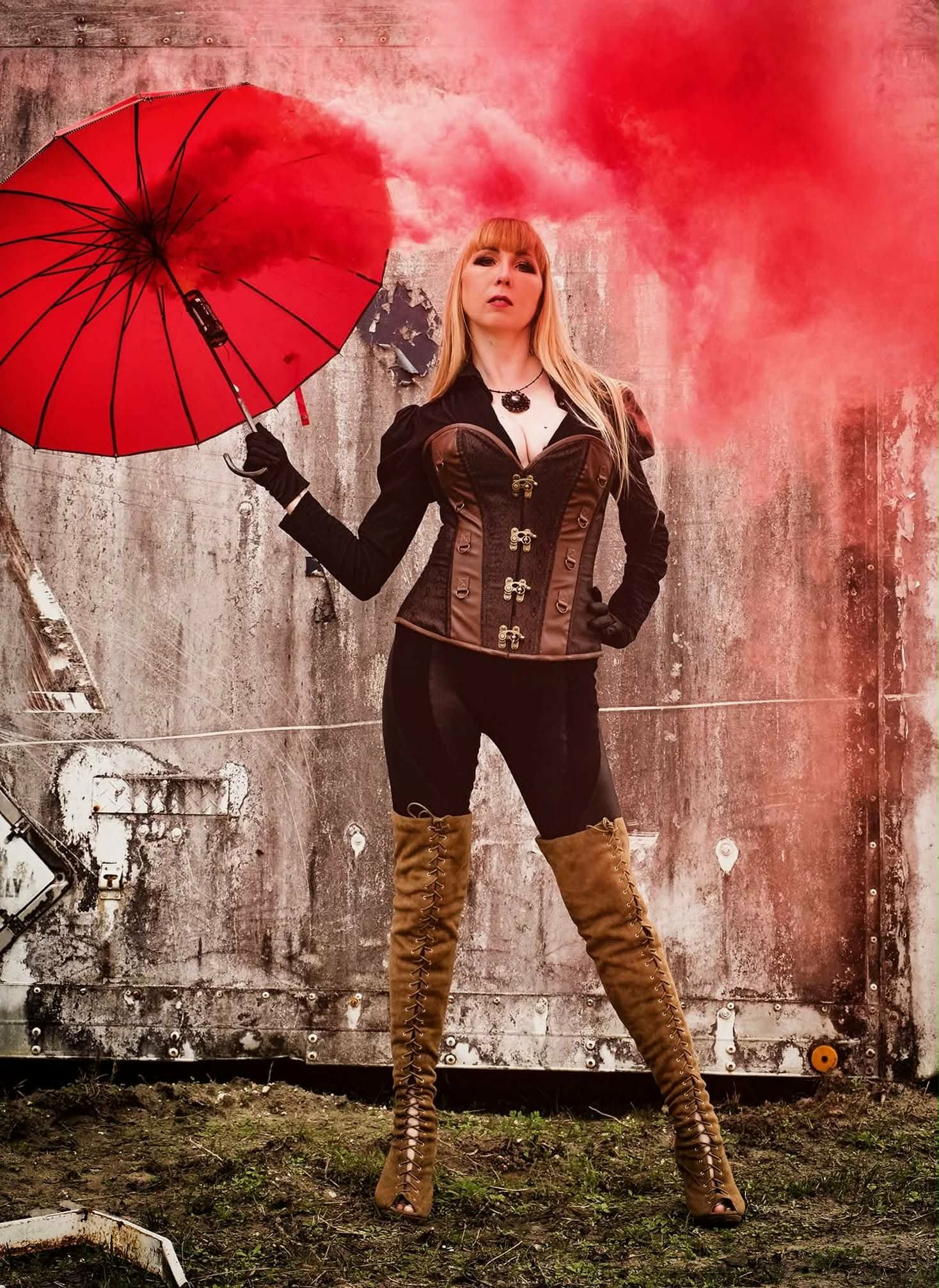 Red-smoke editorial portrait styled with jewelry and accessories by Jenni