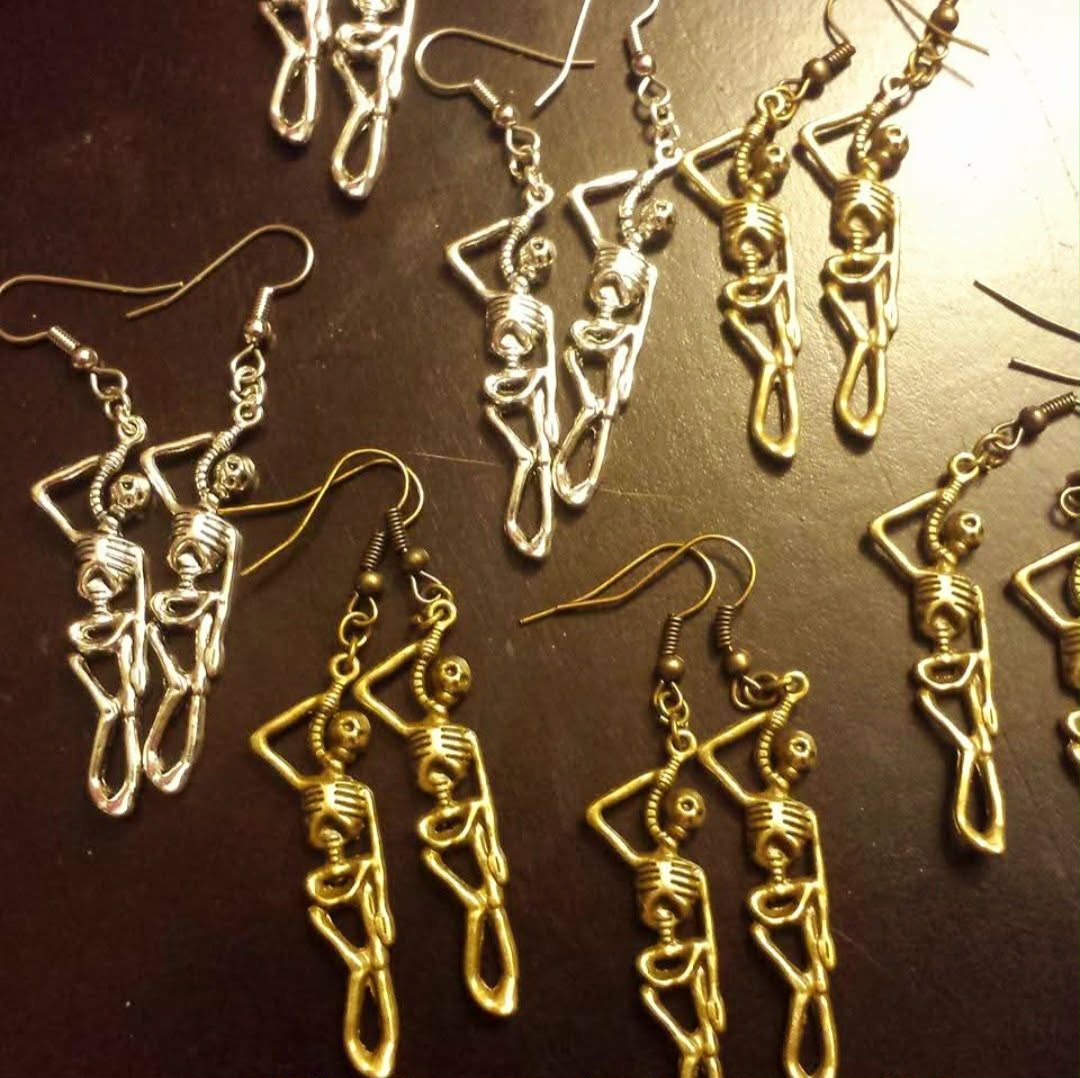 Collection of dangling skeleton-shaped earrings in silver and gold tones